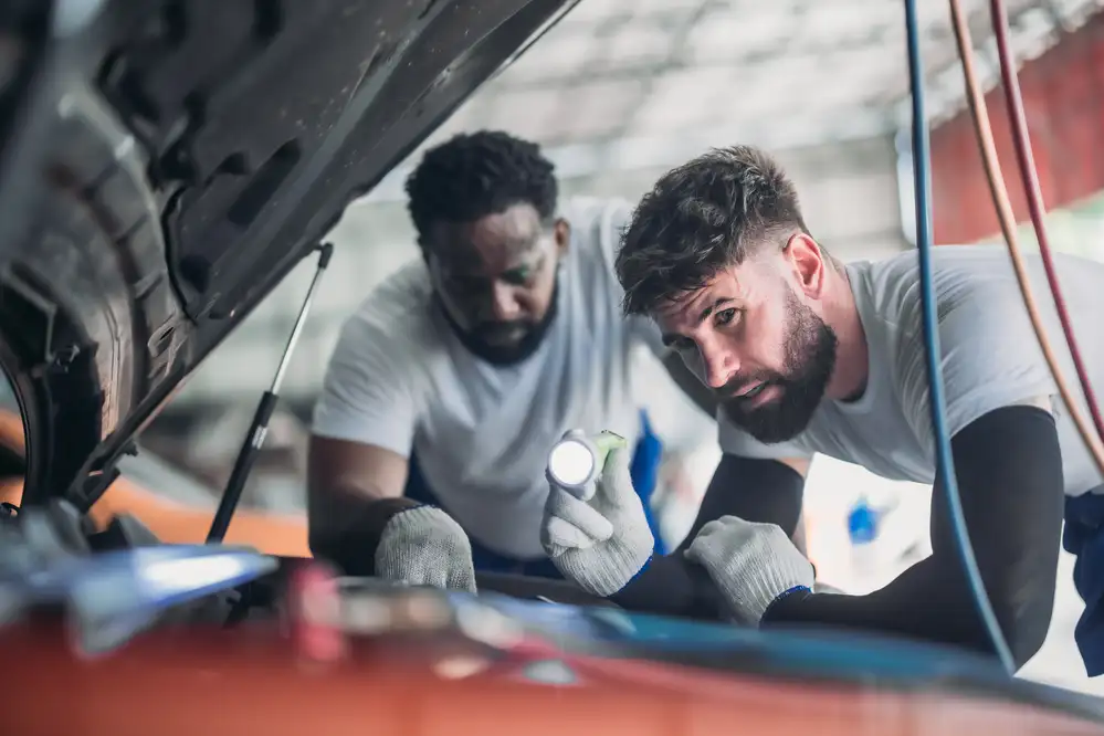Expert inspecting vehicle to identify problems during routine maintenance at Riverfront Auto Dallas in Riverfront, Dallas, TX